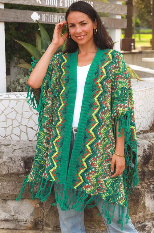 Woman wearing a green and yellow patterned kimono-style garment outdoors.