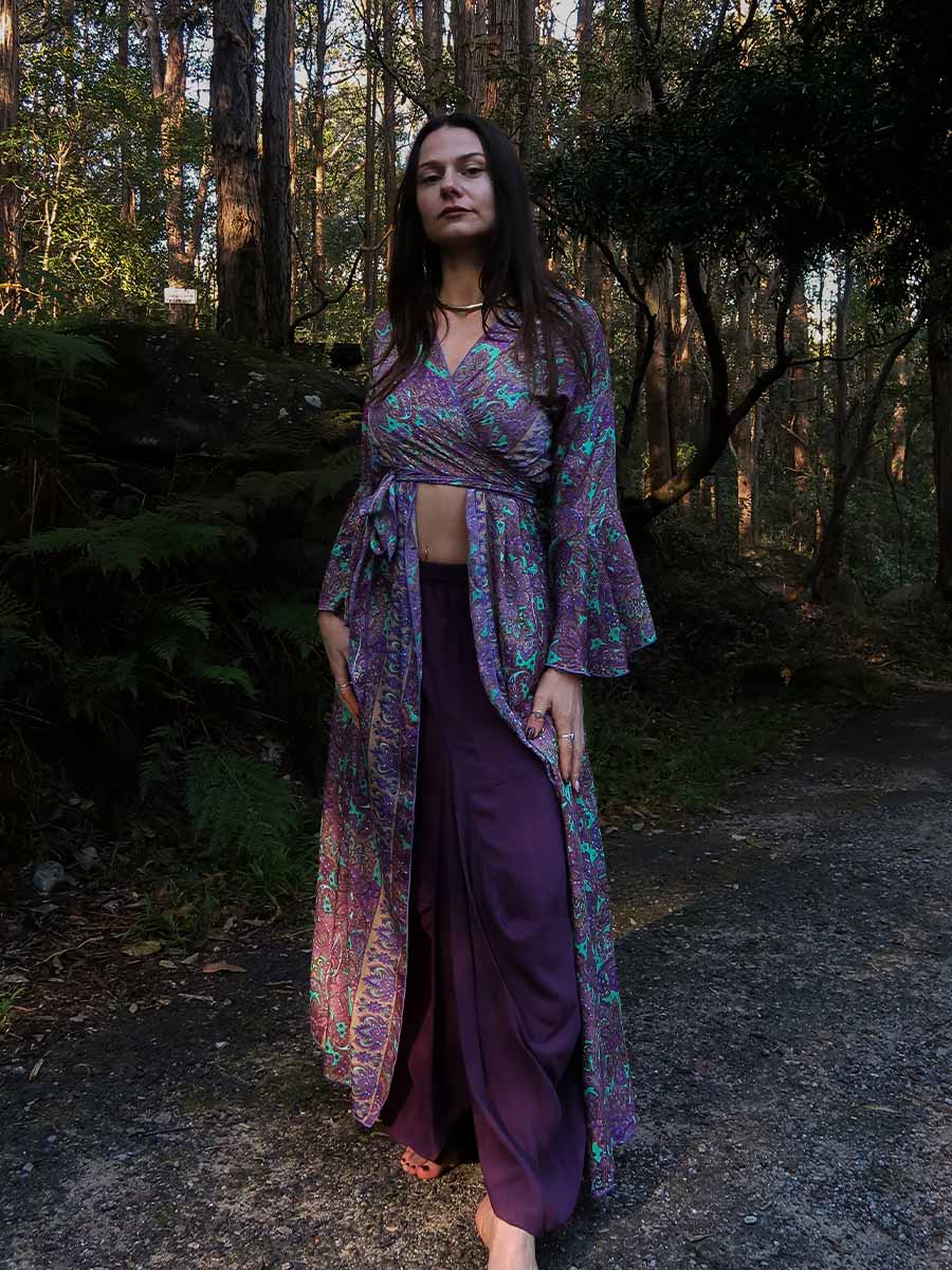 Woman in a purple outfit standing in a forest