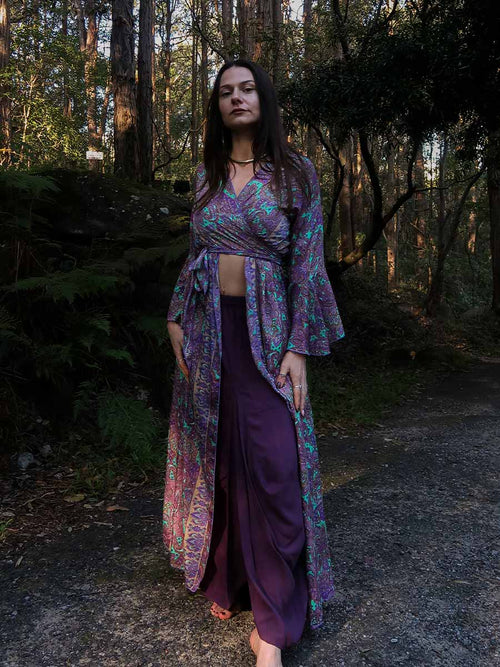 Woman in a purple outfit standing in a forest