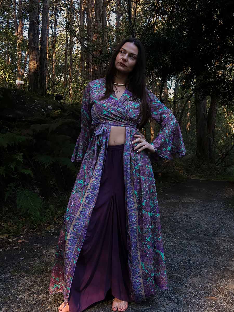 Woman in a patterned dress standing in a forest