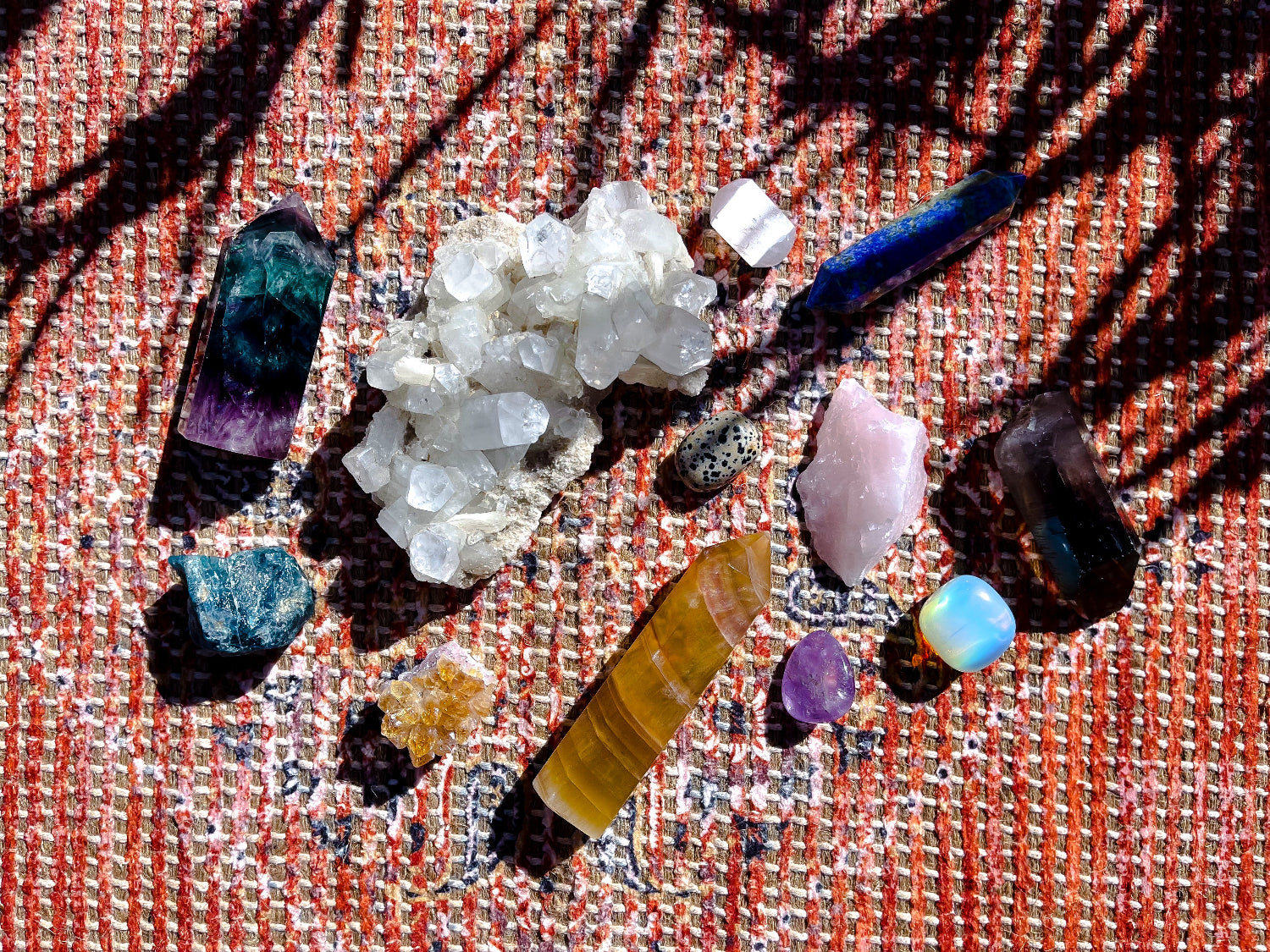 Collection of various crystals and minerals on a textured fabric background