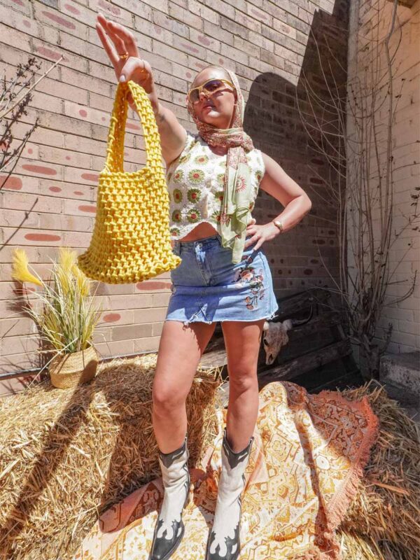 denim skirt with flower embroidery, green vest and yellow bag