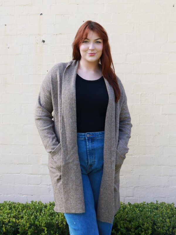 A woman wearing a brown, long, open, knit, cardigan.