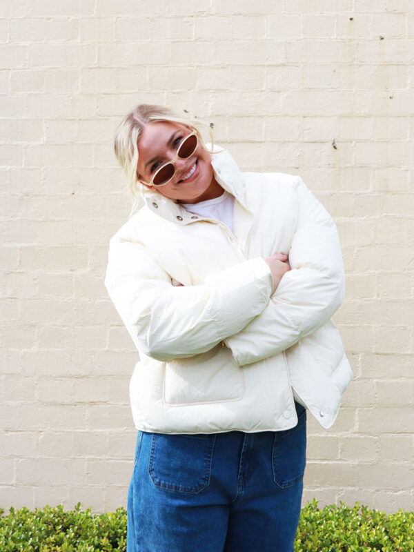 A woman wearing a cream, puffer jacket.