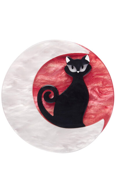 A woman's brooch depicts a black cat sitting on a crescent moon.