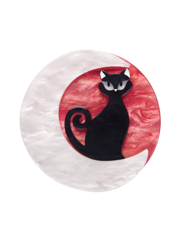 A woman's brooch depicts a black cat sitting on a crescent moon.