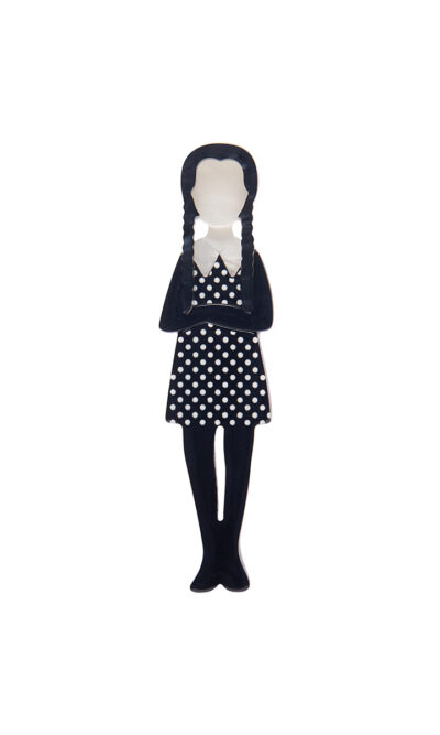 A woman's brooch depicts a Wednesday Adams-inspired character.