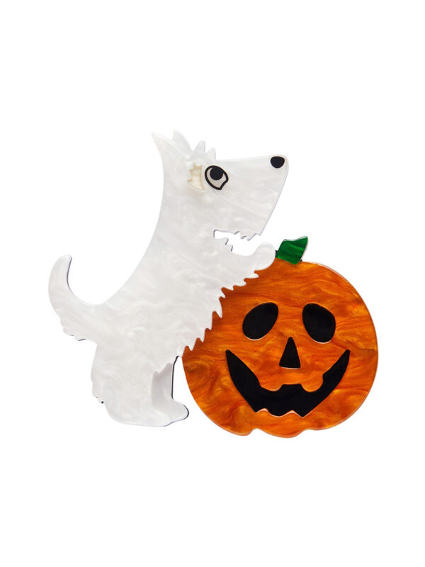 A woman's brooch depicts a white dog with its front legs on a jack-o-lantern.