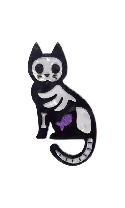 A woman's brooch depicts a cartoon-style X-Ray of a cat.