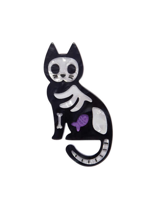 A woman's brooch depicts a cartoon-style X-Ray of a cat.