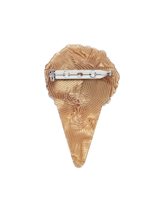 A woman's brooch depicts an ice cream cone cake with sprinkles.