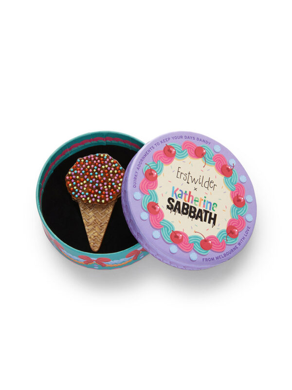 A woman's brooch depicts an ice cream cone cake with sprinkles.