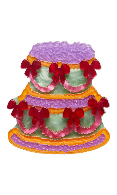 A woman's brooch depicts a vintage style tiered cake.