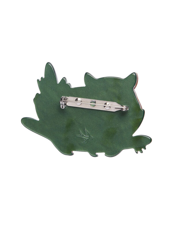 A woman's brooch depicts a relaxed wombat.